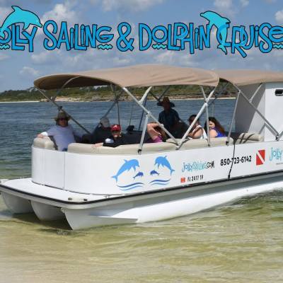 A pontoon boat with people onboard on a sunny day near the shore, with 'Jolly Sailing & Dolphin Cruise' text.