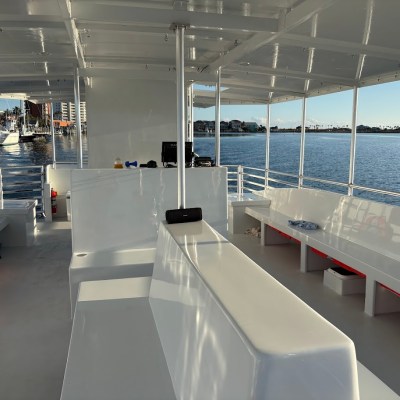 Empty boat interior with benches and open water view in the background.
