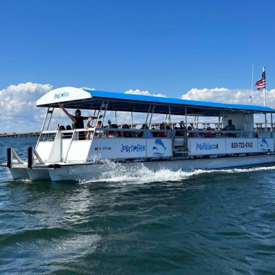 Tour boat with blue roof and passengers sailing on a sunny day.