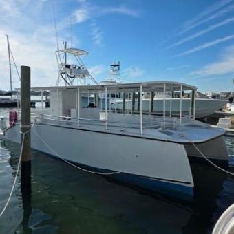 White boat docked at a marina with blue sky in the background.