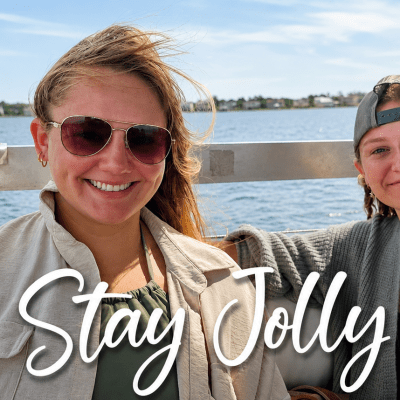 Two people smiling on a boat with water and 'Stay Jolly' text.